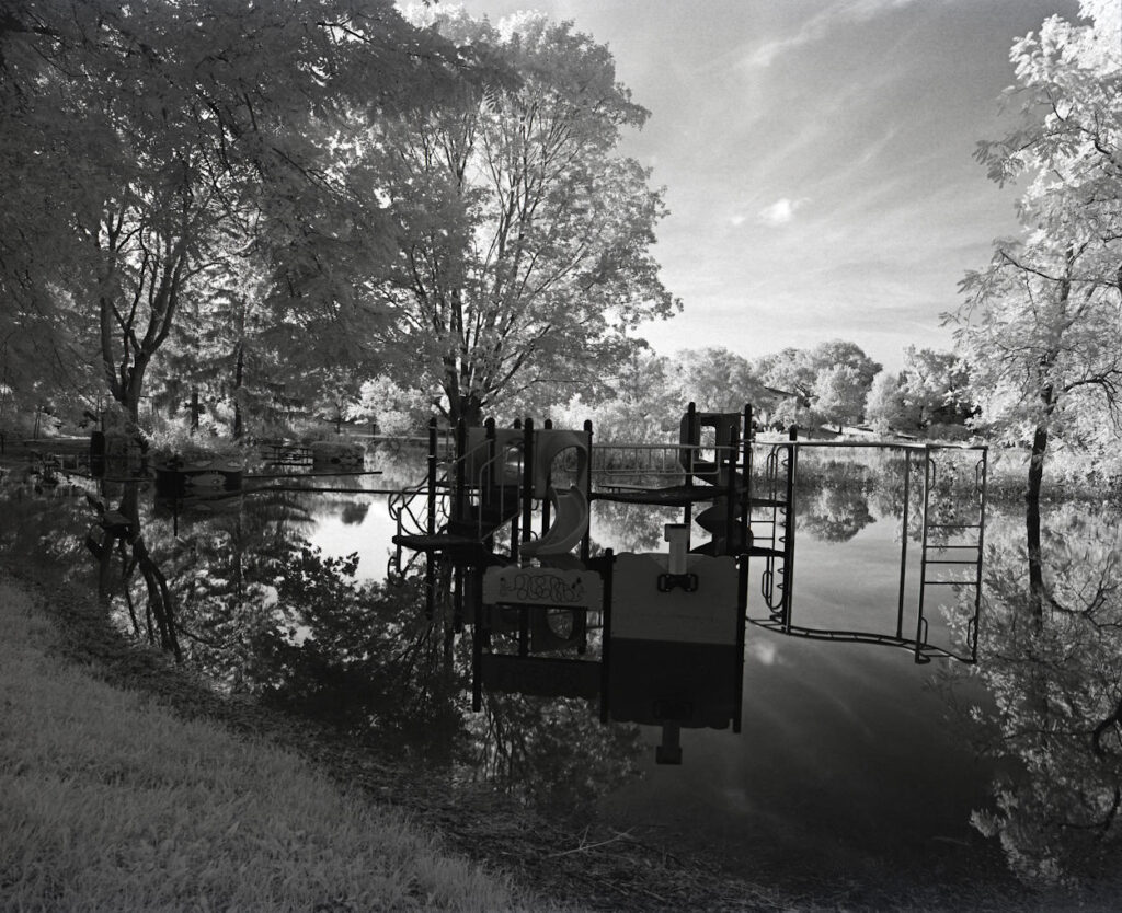 The flooded playground of a local park, shot in monochrome.