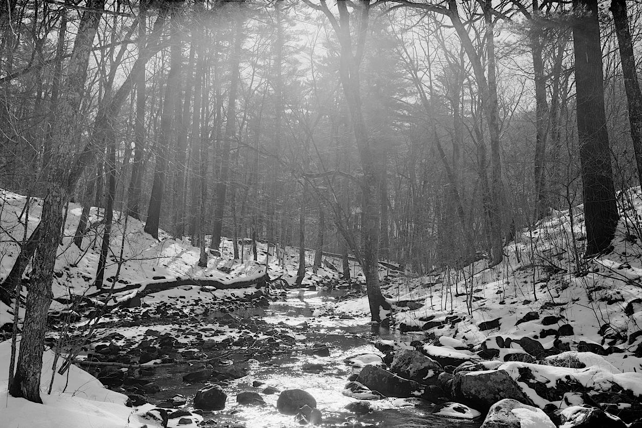 A powerful stream in the dead of winter, seen in monochrome.